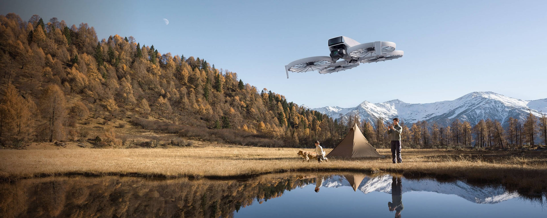 A young boy flying the DJI Flip Camera Drone above a field with trees and mountains in the background 